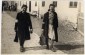 Two young women wearing armbands walk down a street near the  town square in the Bolechow ghetto.  Pictured, on the left, Pepcia  Diamand, murdered during an Aktion in March 1943. © United States Holocaust Memorial Museum, courtesy of  Schlomo Adler